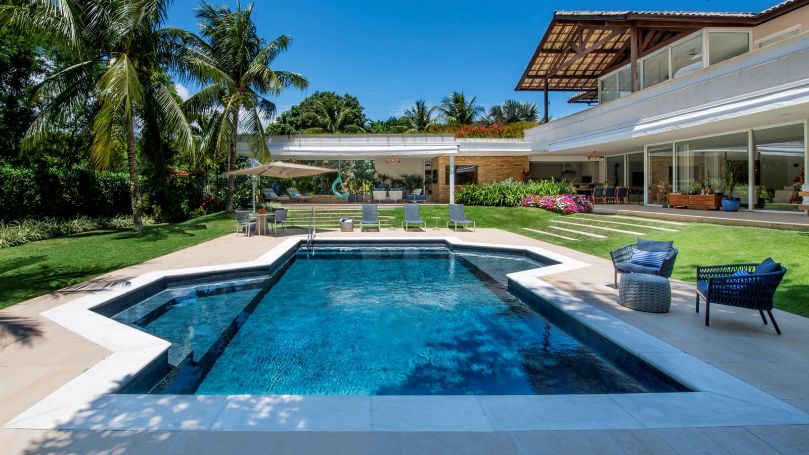 Piscina en jardín tropical con palmeras