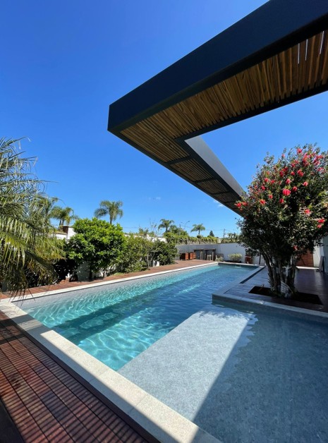 Piscina bajo terraza cubierta de madera